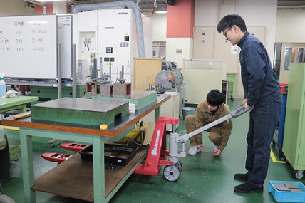 訓練生が運搬用リフトで作業台を持ち上げている写真