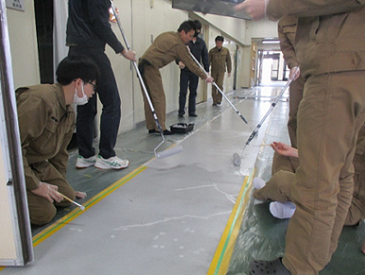 安全通路にローラーで塗料を塗っている写真