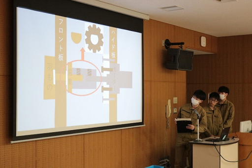 プロジェクターとスライドを使って修了課題の説明をしている写真