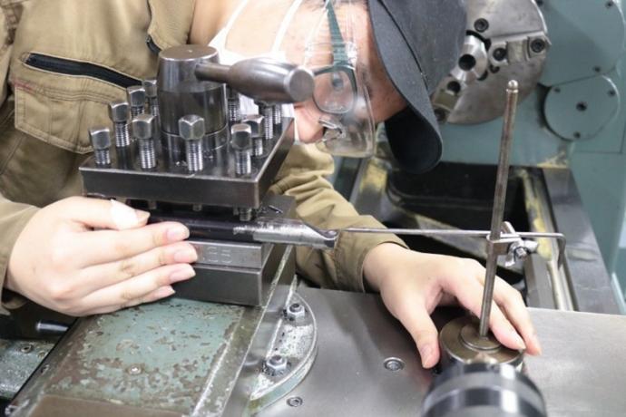 旋盤に取り付けた工具の精度を合わせている様子