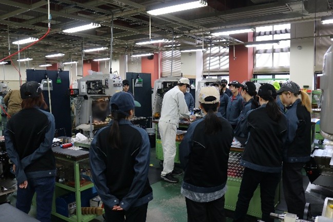 指導員からフライス盤の説明を受けている様子