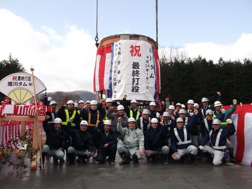 遮水擁壁工打設完了を祝うようす