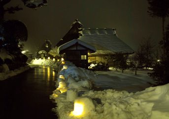 雪灯ろうに照らされたかやぶきの里