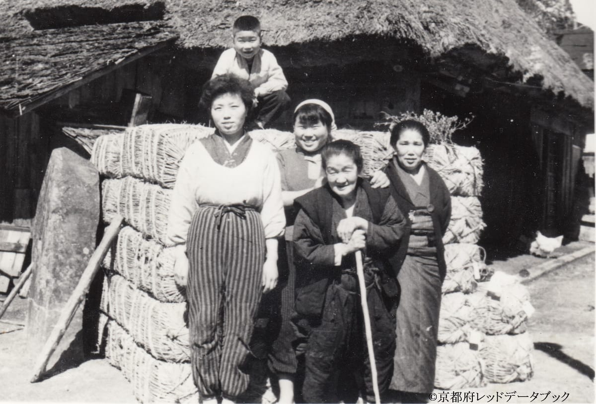 写真16　炭を運んでもらうためにトラックを待っているところ。昭和30年（1955）頃。尾越。左端の大きな石は、朽木の殿様が尾越で泊まり、馬に乗る時の馬乗り石。邪魔になるので、立てたという。