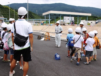 工事中の宮津天橋立本線料金所の説明を聞く児童たち