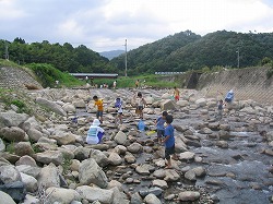 世屋川の木製魚道と川遊びをする子供たちの写真です